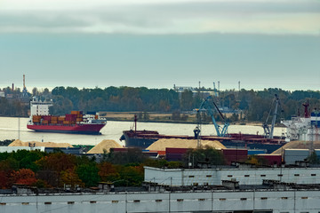 Fototapeta na wymiar Red container ship entering port of Riga, Latvia
