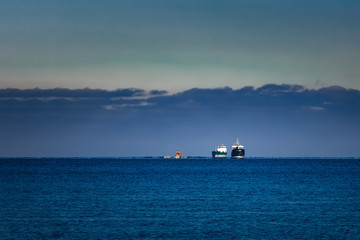 Fototapeta premium Cargo ships far in still water of Baltic sea