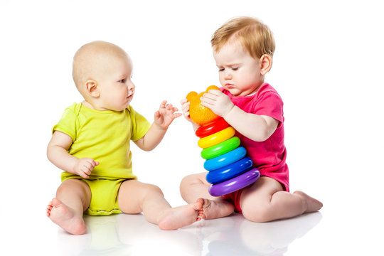 Two kids play dice, pyramid, tumbler in bright clothes
