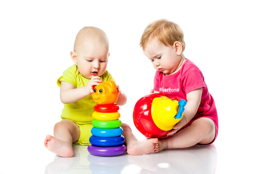 Two kids play dice, pyramid, tumbler in bright clothes