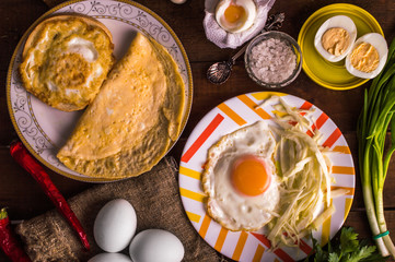 Different cooking eggs on a wooden background