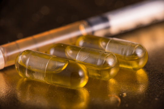 Cannabis extraction capsules infused with shatter over reflective background