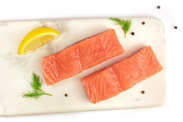 Photo of slices of salmon on white marble with copyspace