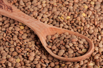 Lentils in a wooden spoon as background