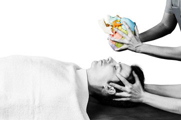 Physiotherapist doing a cranial sacral therapy to a man patient in silhouette studio on white...
