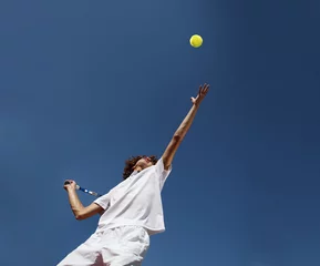 Fotobehang tennis player with racket during a serve in match game © amedeoemaja