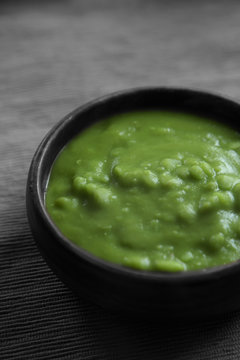 Mushy peas in a wooden bowl.  Edited using selective colour