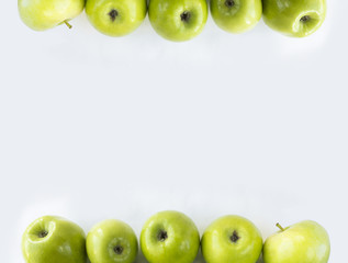 Horizontal seamless background with green apples. Fresh apples on a white background. Apples at border of image with copy space for text.
