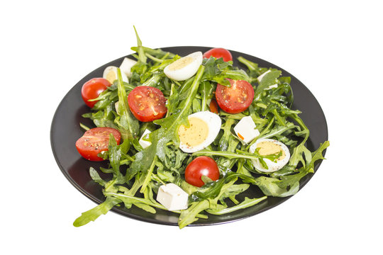 Quail eggs salad on a dark plate