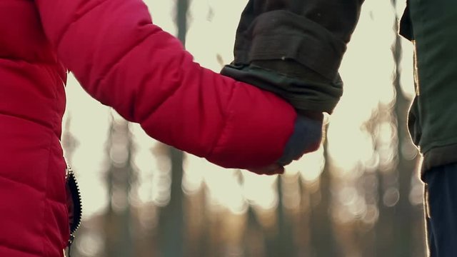 Happy family, Composition. The Hand of Adult Man Unhooks Hands of Young Girl on background of Beautiful Sunset Sun rays. Father and Daughter go Forward, Defocus. Park, Outdoor
