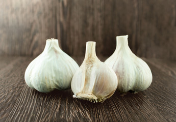Obraz premium Group bulb Head of garlic on wood background with shadow