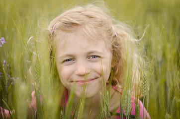 lovely blond girl portrait in green field