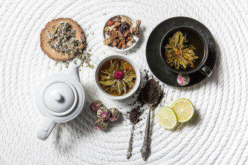 Food background with different black and green dry tea, rose buds cup of hot tea