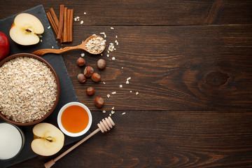 Ingredients for oatmeal on dark wooden table. Concept of healthy food. - 142637318
