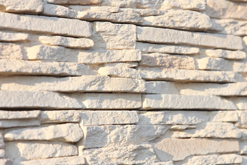 Wall of decorative stone sand color. Shallow depth of field, abstract background.