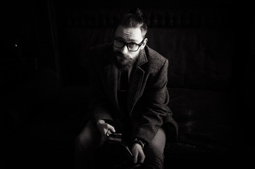 Black and white Portrait of handsome adult man sending a text message,business man reading messages,stylish brunette hipster using cell phone
