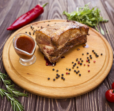 Large piece of pork on a wooden dostichke. Photo for the restaurant menu of meat