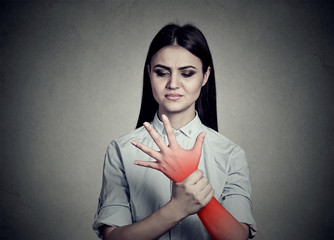 Woman holding her painful wrist colored in red