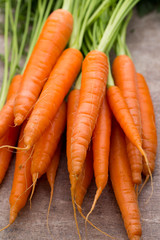 Fresh and sweet carrot on a grey wooden table.