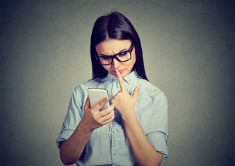 Clueless perplexed girl having troubles with new smartphone