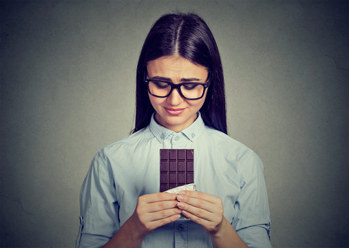 Sad woman tired of diet restrictions craving sweets chocolate bar