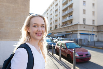 Portrait of woman with backpack on the street on sunset time.