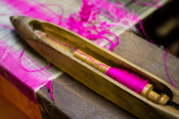 Loom bobbin with purple thread for silk weaving