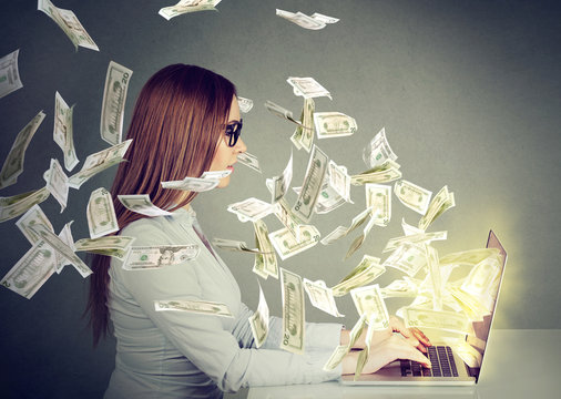 Woman Sitting At Table Using Working On A Laptop Computer Making Money