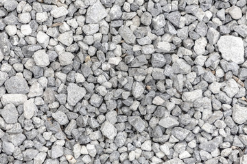 A countryside road full of tiny grey pebbles.
