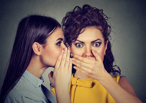 shocked woman listening gossip a secret in the ear