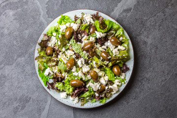 Healthy lettuce salad with cheese feta and olives. top view
