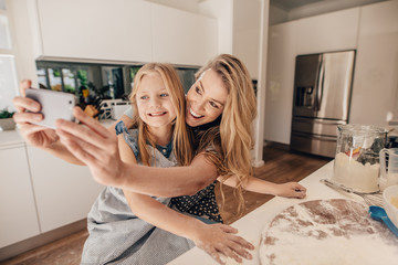 Happy young family of taking selfie in kitchen