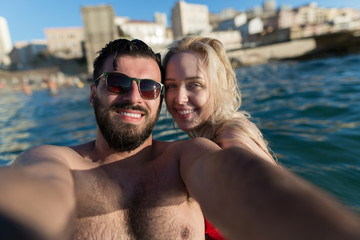 Obraz premium Young and beautiful couple taking selfie at the sea