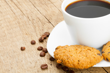 White cup of plain black coffee with cookies next to it
