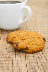 White cup of coffee with cookies next to it