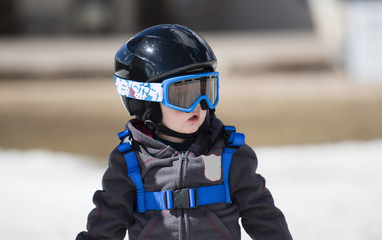 Toddler Boy Ready to Ski with all Safety Gear. Helmet & Harness.