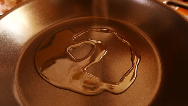 Curry leaves being thrown in a pan with spices, chillies and condiments