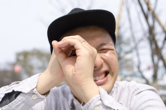 おもしろポーズで感情表現をするキャップ姿の日本人男性｜SNS・YouTubeサムネ向けストックフォト