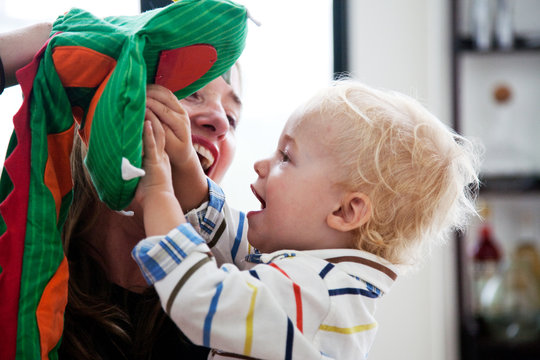 13 month old baby boy playing with puppet with mom