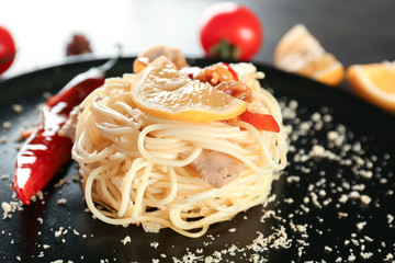Delicious chicken spaghetti with pepper and lemon on plate
