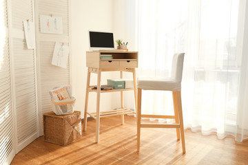 High wooden table as stand up work place in modern interior