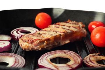Preparing of steak with onion rings and tomatoes on grill pan, closeup