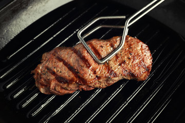 Upturning of fried steak on grill pan, closeup