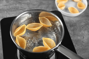 Cooking pasta in pan on stove, closeup