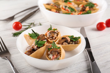 Plate with stuffed pasta on wooden table