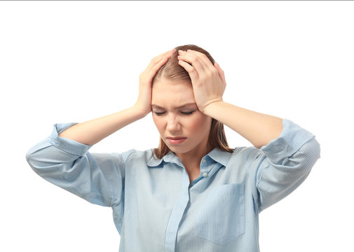 Beautiful young woman suffering from headache on white background