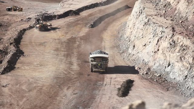 Heavy equipment digs and hauls ore inside an enormus open pit mine.
Chile