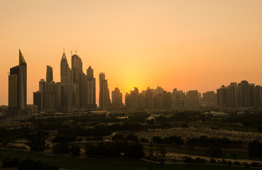 dubai marina dusty sunset cityscape silhouette  shot from the greens golf course. The greens - dubai