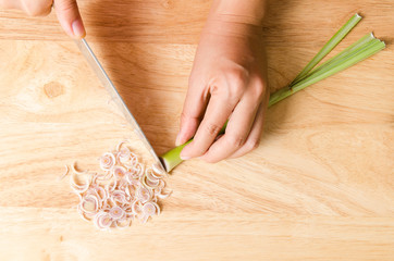 Chef slice lemon grass on wooden board prepare for Thai food cooking
