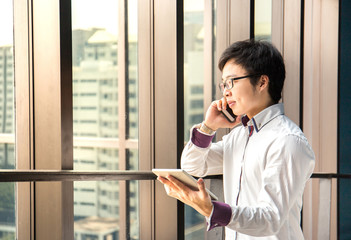 Fototapeta premium Handsome business man working with tablet and smart phone in office